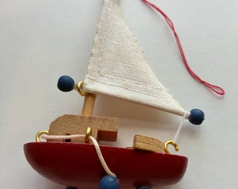 Vintage wooden sailboat ornament, red boat with a canvas sail, nautical Christmas decoration