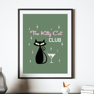 May include: A green poster with a black cat and a martini glass. The text on the poster reads "The Kitty Cat Club" in pink and black lettering.