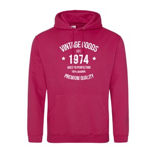 May include: A pink hooded sweatshirt with white text that reads "Vintage Goods Est. 1974 Aged to Perfection 100% Original Premium Quality".