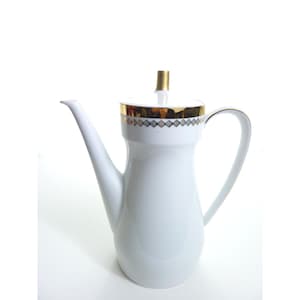 May include: White ceramic coffee pot with a long spout and a handle. The lid and rim are accented with gold trim and a geometric pattern. The lid has a gold finial.