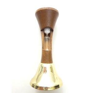 May include: An hourglass with a wooden frame and a gold-colored base. The hourglass has a clear glass tube containing white sand. The wooden frame is a dark brown color.