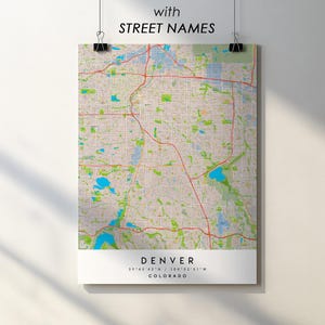 May include: A map print of Denver, Colorado, with street names. The map features a detailed layout of the city with red roads, blue water features, and green park areas. The text "DENVER" and coordinates are at the bottom.