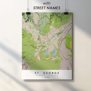 Könnte beinhalten: Ein detaillierter Kartendruck von St. George, Utah, mit Straßennamen, auf weißem Hintergrund. Die Karte zeigt grüne, beige und rote Farben, mit dem Text "with STREET NAMES" oben. Der Name der Stadt und die Koordinaten stehen unten.
