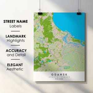 Könnte beinhalten: Eine detaillierte Karte von Gdańsk, Polen, mit blauem Meer und grünen Landflächen. Das Poster, gehalten von schwarzen Klammern, hebt Straßennamen und Sehenswürdigkeiten hervor. Der Text lautet "Gdańsk, Polen".