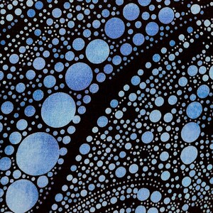 May include: A black fabric featuring a pattern of blue and light blue circular dots of varying sizes arranged in flowing, wave-like lines. A ruler showing 10 inches is positioned along the left edge to indicate the scale of the print.