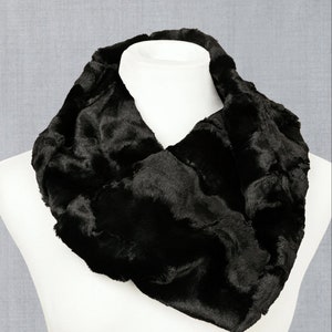 May include: A black faux fur neck warmer. The neck warmer is soft and fluffy and is perfect for keeping warm in the winter.