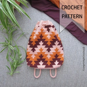 May include: A crochet pattern for a pink, orange, and brown geometric tote bag with a drawstring closure and two straps. The pattern is available on the website @thestoryofamulberry.