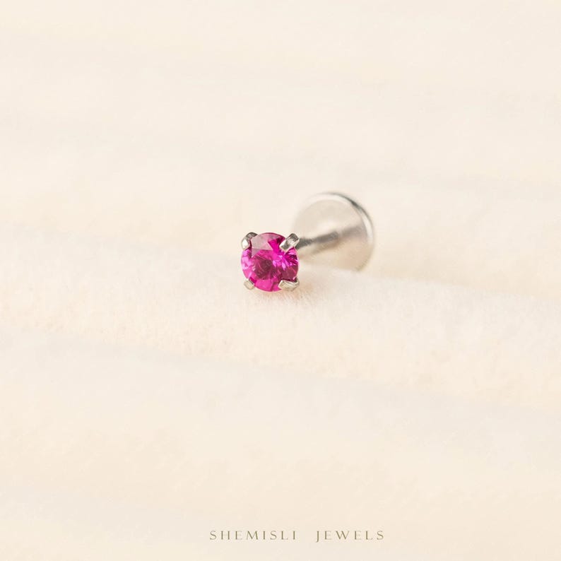 A single pink gemstone is displayed against a light background.