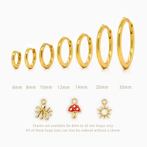 May include: A set of seven gold hoop earrings in graduated sizes from 6mm to 30mm, accompanied by three gold charms: an octopus, a red-capped mushroom, and a sun. Text indicates charms are for 8mm to 20mm hoops and hoops are available plain.