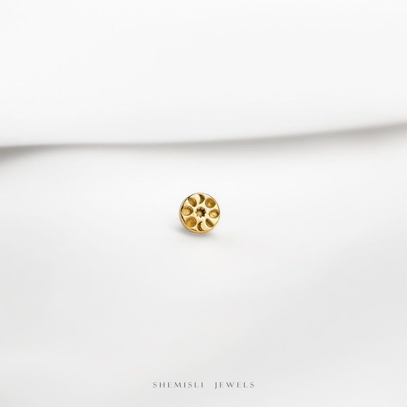 a close up of a gold plated object on a white surface