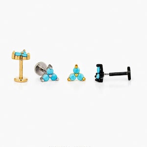 May include: Four pieces of jewellery, including earrings and studs, are displayed. The jewellery features turquoise-coloured stones and gold and black metal accents. The pieces are arranged on a white background, highlighting their design and details.