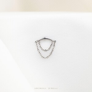 a silver ring with a chain hanging from it