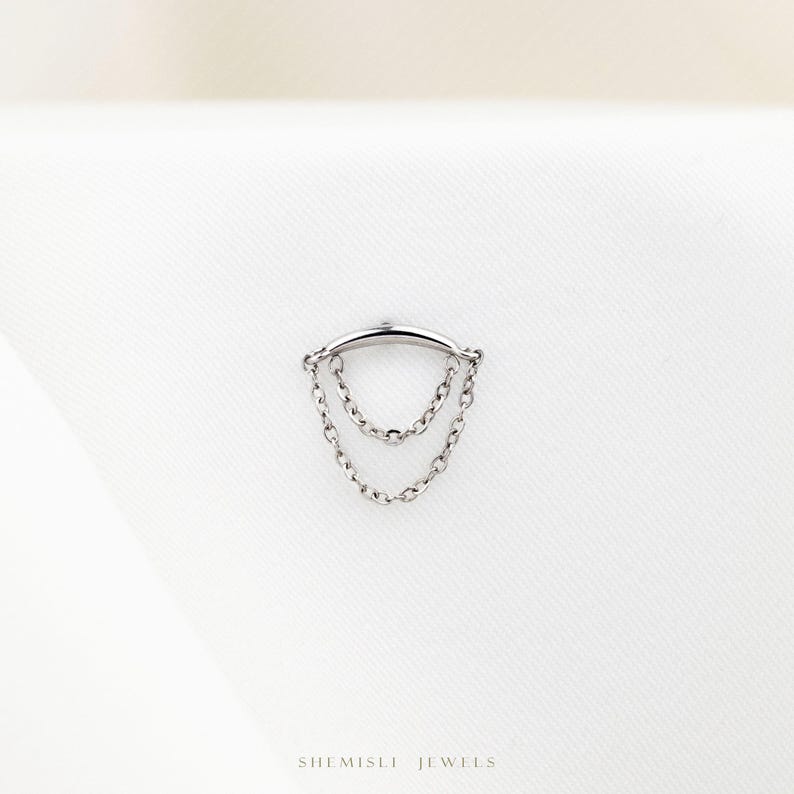 a silver ring with a chain hanging from it