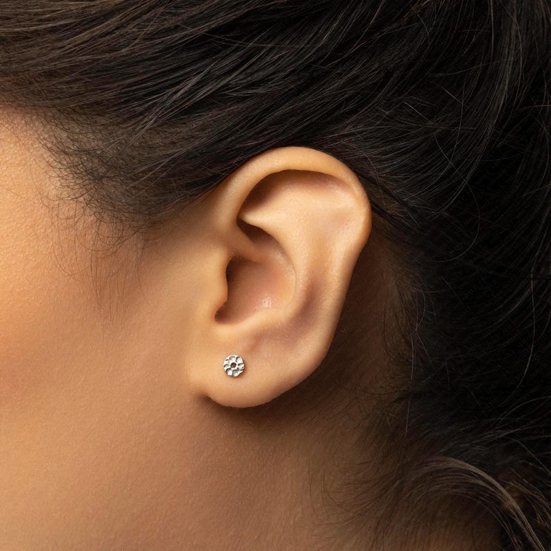 a close up of a person wearing a pair of ear piercings
