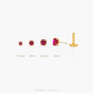 May include: Gold-coloured stud earrings with red gemstones, displayed in sizes 1.5mm, 2mm, 2.5mm, and 3mm. The image also shows a single earring post. The brand name "SHEMISLI JEWELS" is at the bottom of the image.