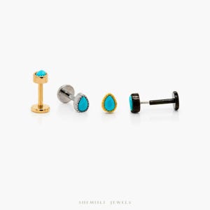 May include: Four stud earrings with turquoise gemstones. One is gold-coloured, one silver-coloured, one gold-coloured with a beaded edge, and one black. The earrings are displayed against a white background.