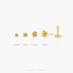 May include: A selection of gold stud earrings with yellow gemstones, varying in size from 1.5mm to 3mm. The earrings are presented against a white backdrop, highlighting their design and size differences. The brand name "SHEMISLI JEWELS" is at the bottom.