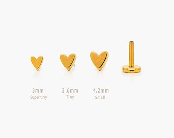 May include: Gold heart-shaped earrings in three sizes: 3mm, 3.6mm, and 4.2mm. The earrings are labelled "Super tiny", "Tiny", and "Small". One earring has a post for piercing. The brand name "SHEMISLI JEWELS" is at the bottom.