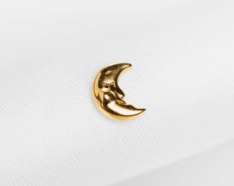 May include: A gold-coloured crescent moon charm with a smiling face. The charm is set against a white background. The text "SHEMISLI JEWELS" is at the bottom of the image.