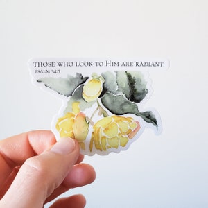 May include: A watercolor sticker with a floral design of yellow flowers and green leaves. The sticker has the text "THOSE WHO LOOK TO HIM ARE RADIANT. PSALM 34:5"