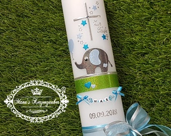 Può includere: Una candela bianca decorata con un elefante blu e argento, stelle e una croce. La candela ha il testo "Zur Taufe" e "09.09.2018". Uno striscione recita "MAX". La candela è adornata con nastri blu e una fascia verde.