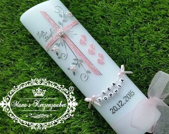 May include: A light blue baptism candle with pink cross, floral accents, and the text "Zur Taufe". The candle features a pink ribbon, a beaded name tag, and the date "20.12.2015".