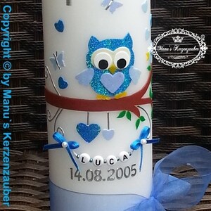 Peut inclure: Une bougie blanche d&eacute;cor&eacute;e d'un hibou bleu, de papillons et de c&oelig;urs. Le nom "LUCA" et la date "14.08.2005" sont affich&eacute;s. Un ruban et un n&oelig;ud bleus ajoutent une touche d&eacute;corative. La bougie est un article personnalis&eacute;.