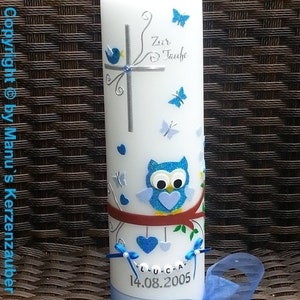 Peut inclure: Une bougie blanche d&eacute;cor&eacute;e de papillons bleus, d'une croix et d'un hibou. La bougie porte l'inscription "Zur Taufe" et le nom "Luca" avec la date "14.08.2005". Un ruban et un n&oelig;ud bleus sont &agrave; la base.