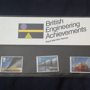 Könnte beinhalten: Ein Satz von drei britischen Royal Mail Briefmarken mit Motiven aus der Ingenieurskunst. Die Briefmarken befinden sich in einem schwarzen Rahmen mit weißem Rand. Die Briefmarken zeigen eine Brücke, ein Schiff und eine Ölplattform.