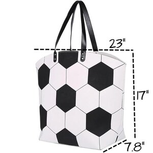 Puede incluir: Un bolso tote blanco y negro con estampado de bal&oacute;n de f&uacute;tbol y asas negras. El bolso mide 58 cm de largo, 43 cm de alto y 20 cm de ancho. El bolso tiene cierre de cremallera y est&aacute; dise&ntilde;ado para transportar objetos.
