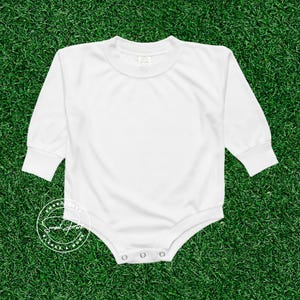 May include: White long-sleeve bodysuit with a crew neck and snap closures at the bottom.