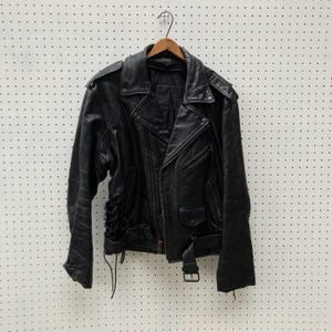 May include: A black leather biker jacket with a zip fastening and a lace-up detail at the waist.