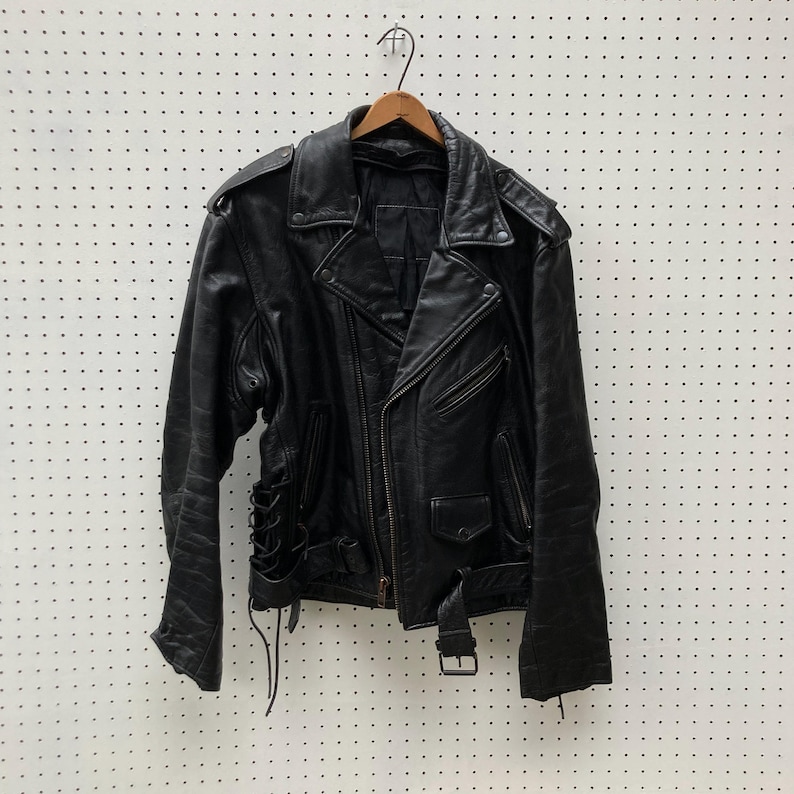 May include: A black leather biker jacket with a zip fastening and a lace-up detail at the waist.