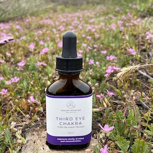 May include: A brown glass bottle with a dropper top, labeled "Healing Mountain Organics Third Eye Chakra Wild Harvested Tincture 30ml Improves clarity of mind and concentration."
