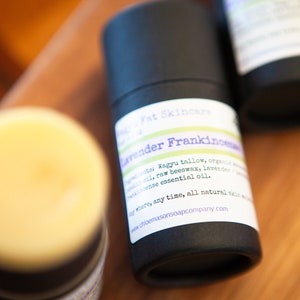 May include: A black tube of lavender and frankincense balm with a white label that reads "Fat Skincare Lavender Frankincense" and lists the ingredients: Wagyu tallow, organic beeswax, lavender and frankincense essential oil. The label also says "where, any time, all natural skin care" and includes the website address www.choemarsonsoapcompany.com.