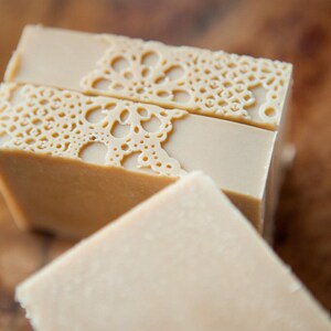 Pu&ograve; includere: Tre saponette fatte a mano con un delicato motivo a pizzo sulla parte superiore. Il sapone &egrave; di colore beige chiaro.
