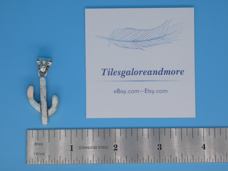 May include: A silver-toned cactus pendant with white and pink opal-like inlays. The pendant is next to a ruler and a card with the text "Tilesgaloreandmore" and "eBay.com~Etsy.com" on a blue background.