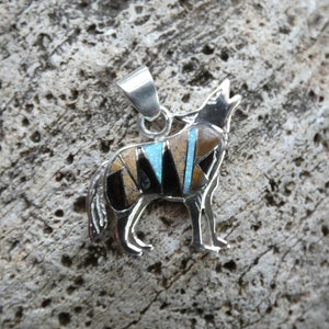 May include: Sterling silver pendant featuring a howling wolf design. The wolf is inlaid with various gemstones, including turquoise, black onyx, and tiger's eye.