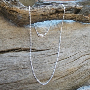 May include: A silver rope chain necklace with a lobster clasp.