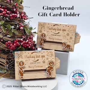 Puede incluir: Tarjeteros de madera con diseños de hombre de jengibre y navideños. El texto en los soportes dice "I fucking love you" y "Merry Christmas". Los soportes están decorados con hombres de jengibre, bastones de caramelo y copos de nieve.