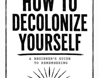 May include: A rectangular white sign with black text that reads HOW TO DECOLONIZE YOURSELF, A BEGINNER'S GUIDE TO REMEMBERING, BY @ALEXISADELINA. Below the text is a black semi-circle graphic with radiating lines resembling a rising sun.