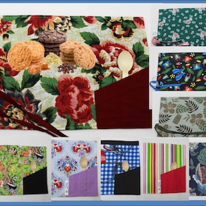May include: A collection of ten fabric placemats with different patterns and colours. Each placemat has a pocket for a wooden spoon. The patterns include floral, animal, and geometric designs.