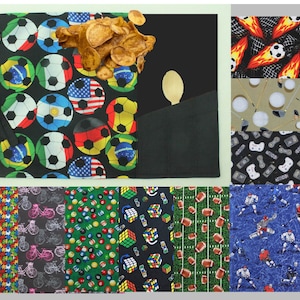 May include: A collection of fabric swatches featuring various sports-themed patterns. The swatches include footballs, rugby balls, basketballs, ice hockey players, video game controllers, golf balls, and crisps.