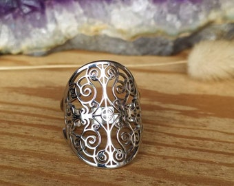 Puede incluir: Un anillo de plata con un diseño delicado e intrincado que se asemeja a un árbol de la vida. El anillo está hecho de metal y tiene un patrón de filigrana.