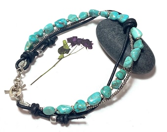 May include: A turquoise stone bracelet with three strands of black leather cord and silver beads. The bracelet has a silver clasp.
