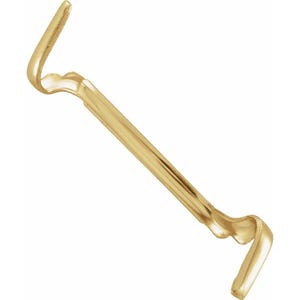 May include: A gold-coloured window sash lock. The lock features a curved design with a central bar and two hooked ends. The metal has a polished finish, reflecting light. The overall shape is elongated and symmetrical.