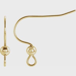 May include: A pair of gold-toned earring hooks featuring a curved wire design, a small decorative ball accent, and a circular loop at the bottom for attaching jewelry components. These metal findings are designed for creating custom earrings.