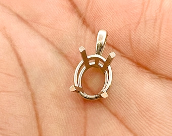 May include: A gold-toned metal pendant setting for an oval-shaped gemstone. The setting has four prongs and a bail for attaching a chain.