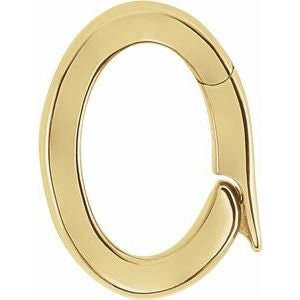 May include: A gold-colored, oval-shaped clasp with a curved, teardrop-like extension. The clasp appears to be hinged, suggesting it can open and close. The surface is smooth and reflective, indicating a polished finish. The design is simple and elegant.