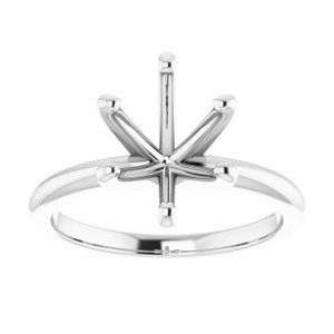 Könnte beinhalten: Eine silberne Ringfassung mit einem sechszackigen Kopf, die für einen Mittel-Stein ausgelegt ist.